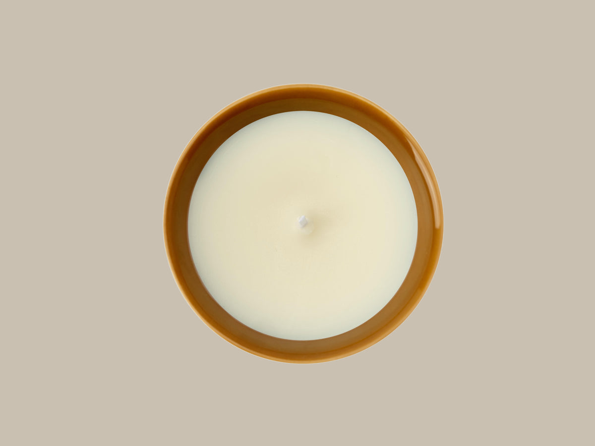 Close-up overhead view of the unlit Ambered Apple candle showing the wax surface and wick