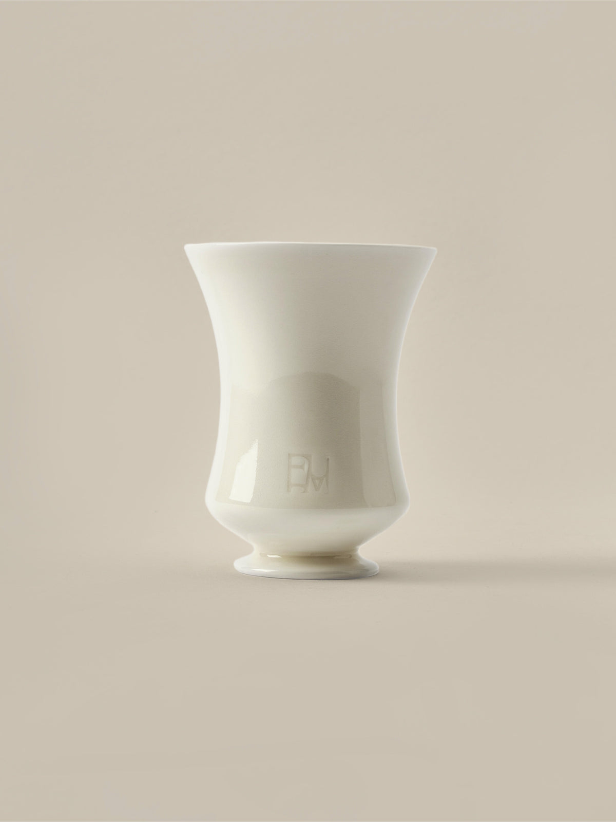Cream ceramic Fume candle vessel on a beige background