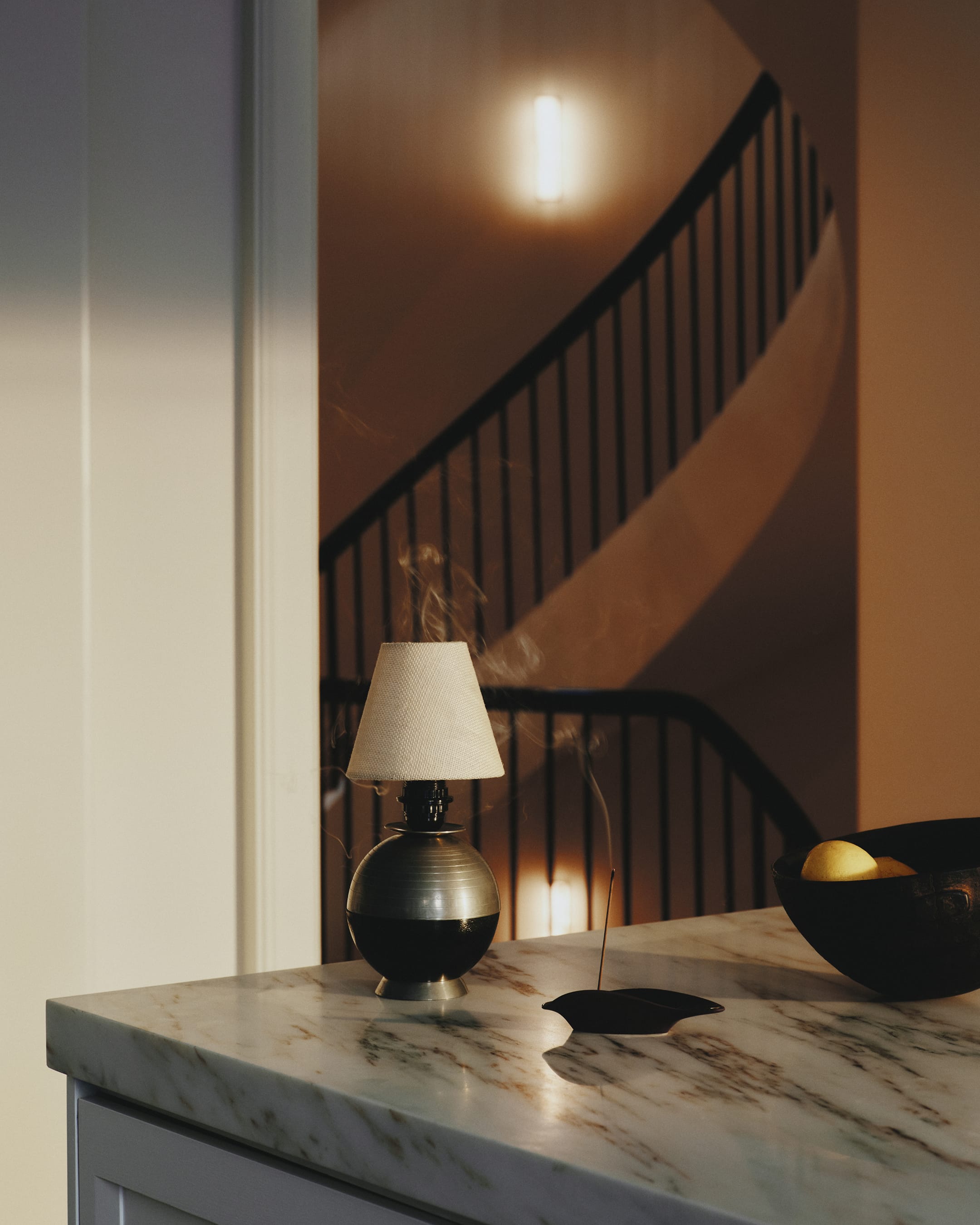 Decorative lamp on a marble surface with a staircase in the background